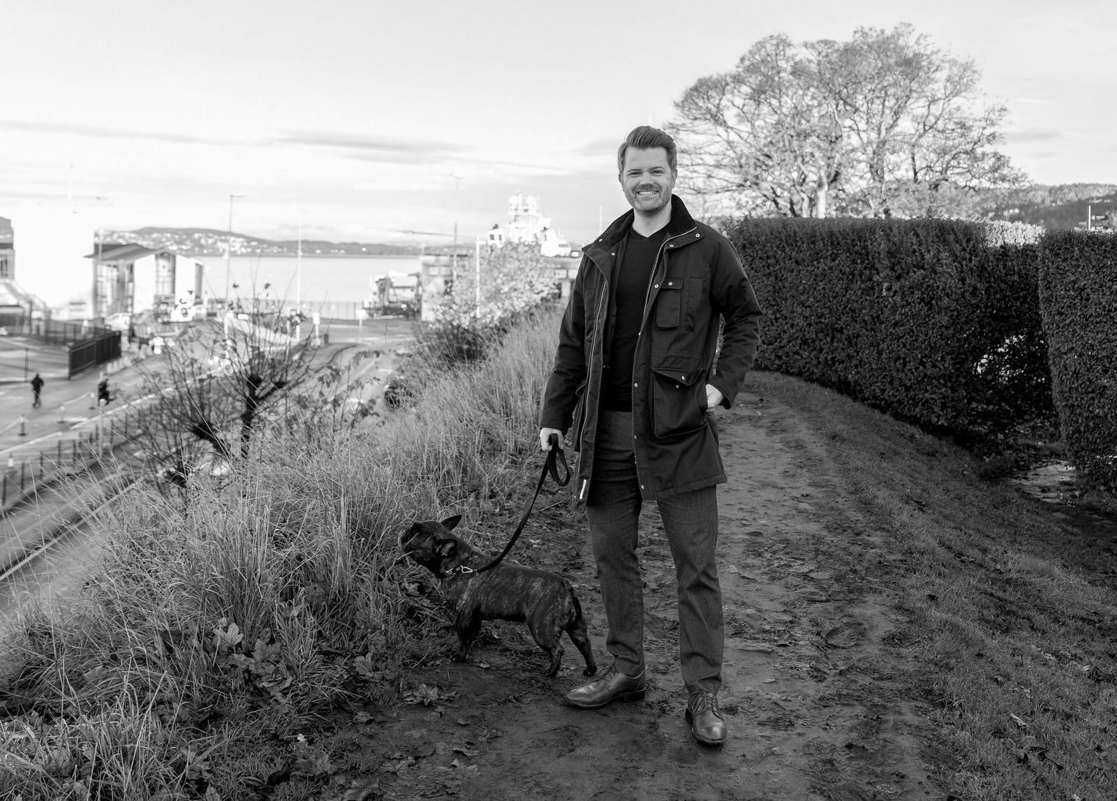 Tommy Nodland går tur med hunden sin på en sti over Bergen havn